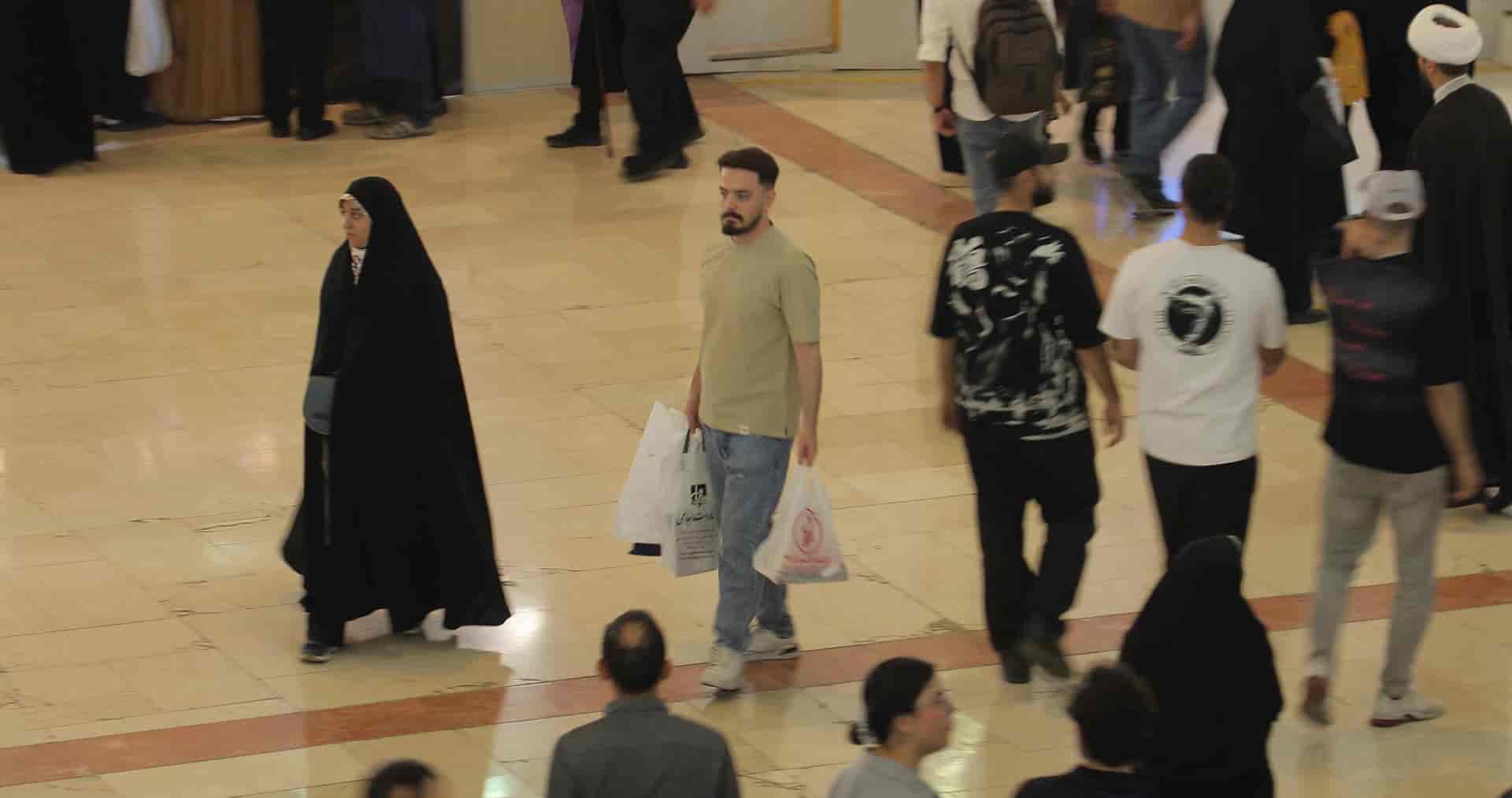 مرد با کیسه خرید در نمایشگاه کتاب 2